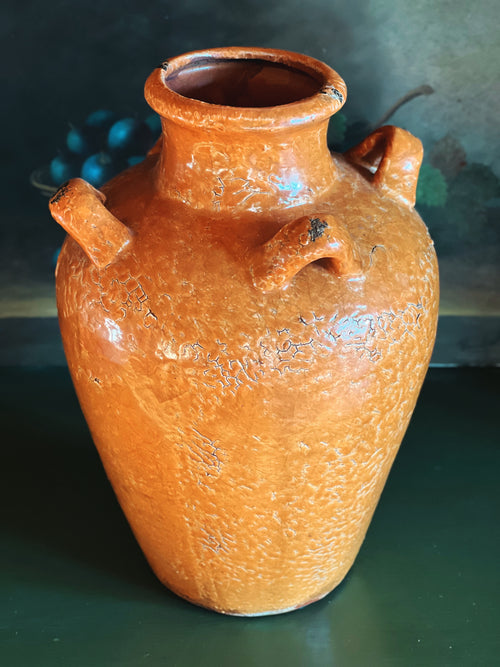 Terracotta jar with a textured surface on a dark background