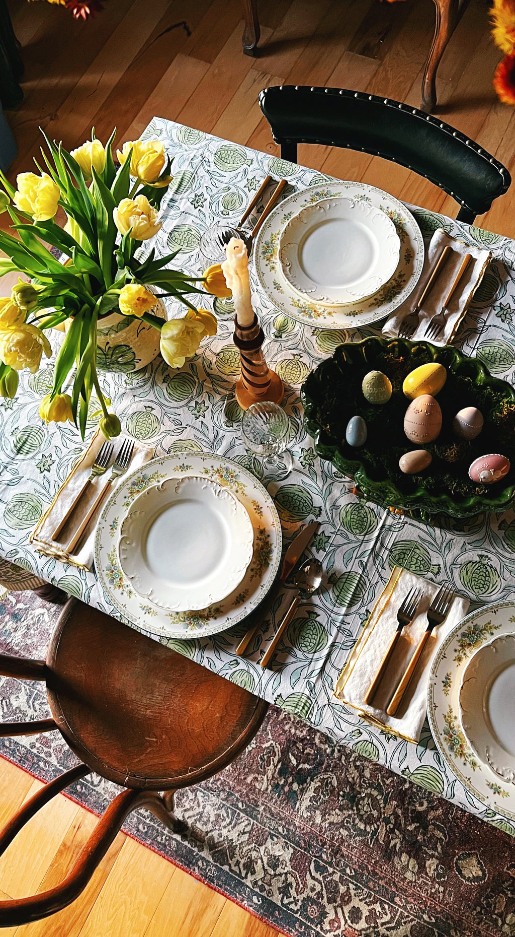 Top view of patterned Spanish tablecloth with layered place setting and vintage plates