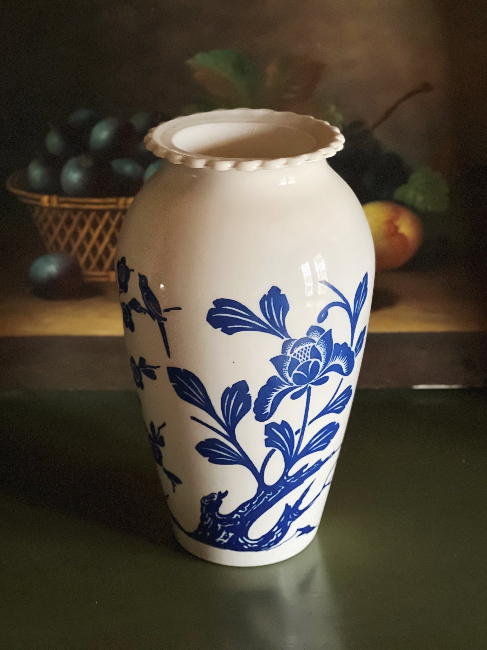 White vase with blue floral patterns on a dark surface with blurred background