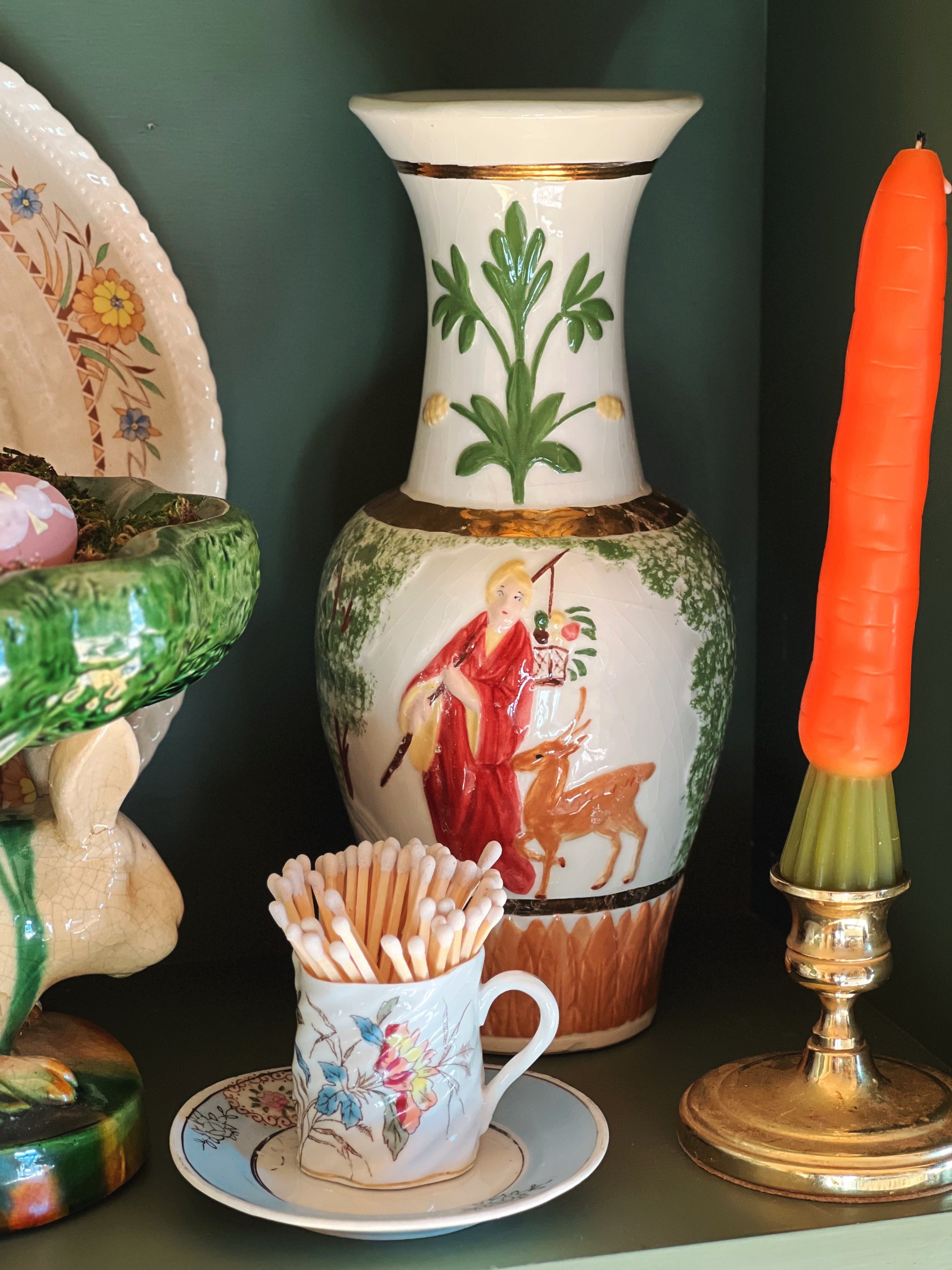 Decorative items including a vase, cup with toothpicks, and candle on a dark surface.