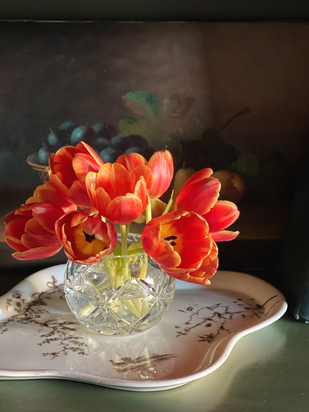 Antique transferware platter with a crystal bowl of tulips placed on top