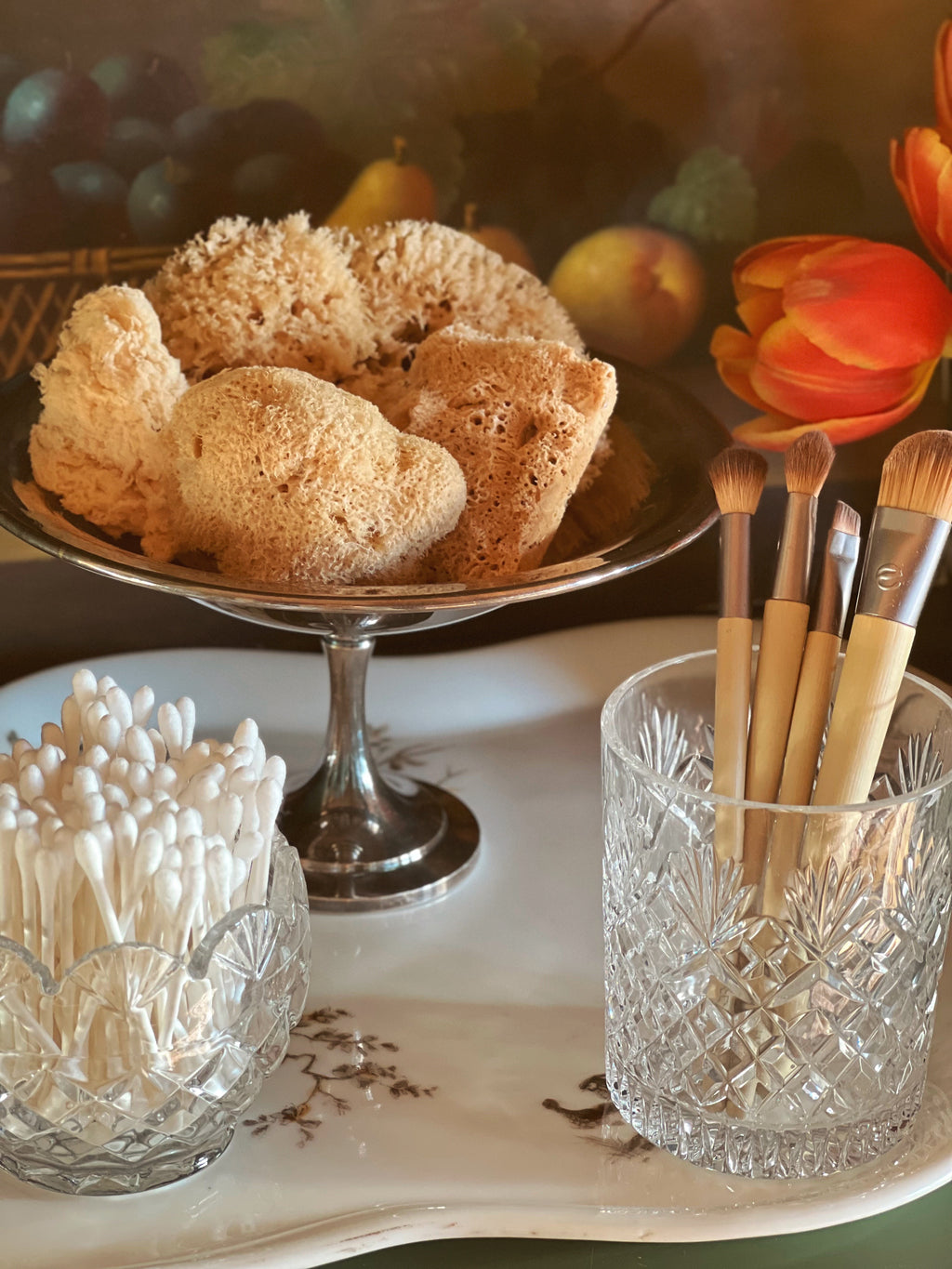 Tray with sponges, makeup brushes, and toothpicks on a decorative background