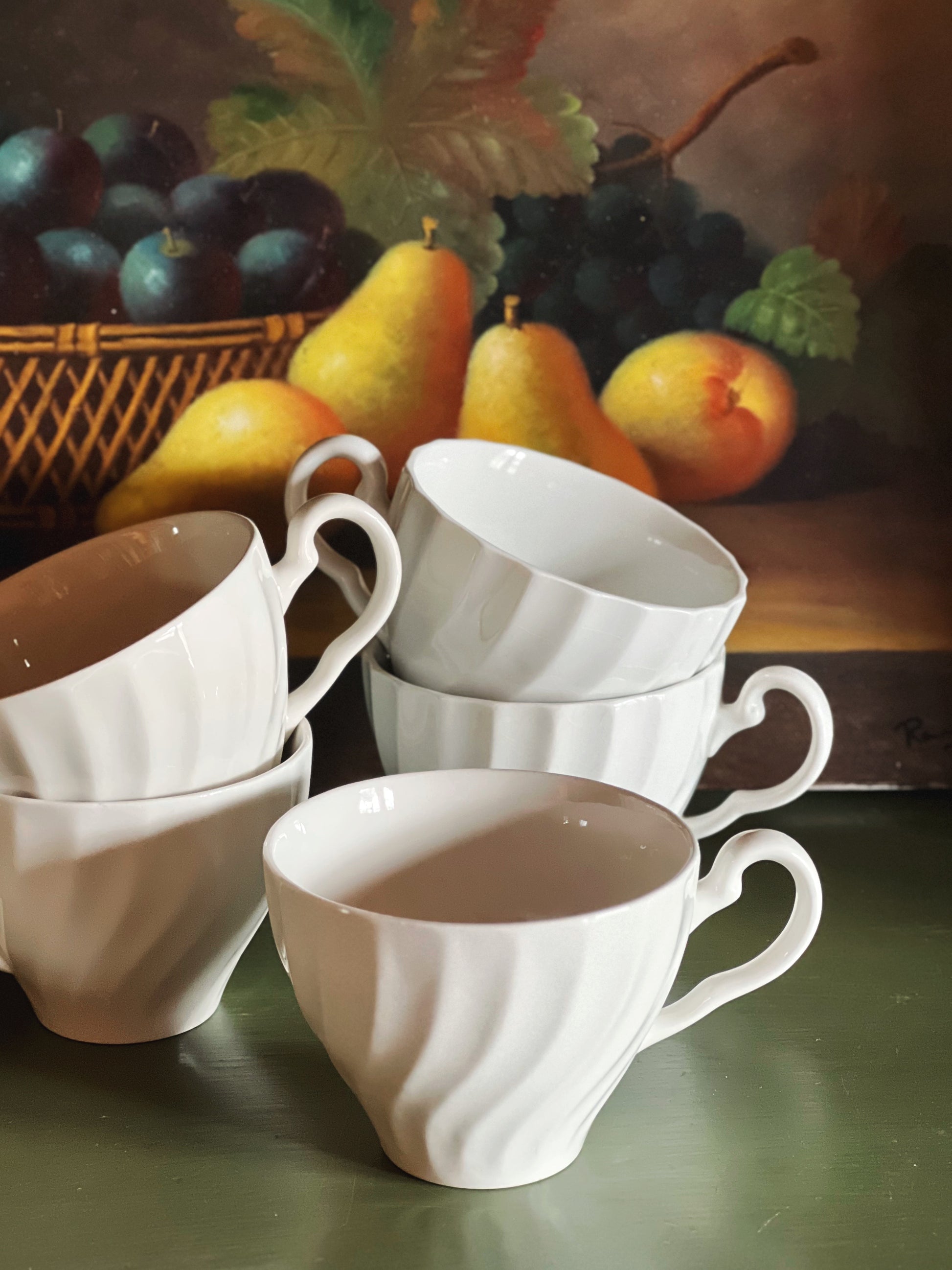 Stacked vintage white ironstone teacups in the Johnson Brothers Regency pattern