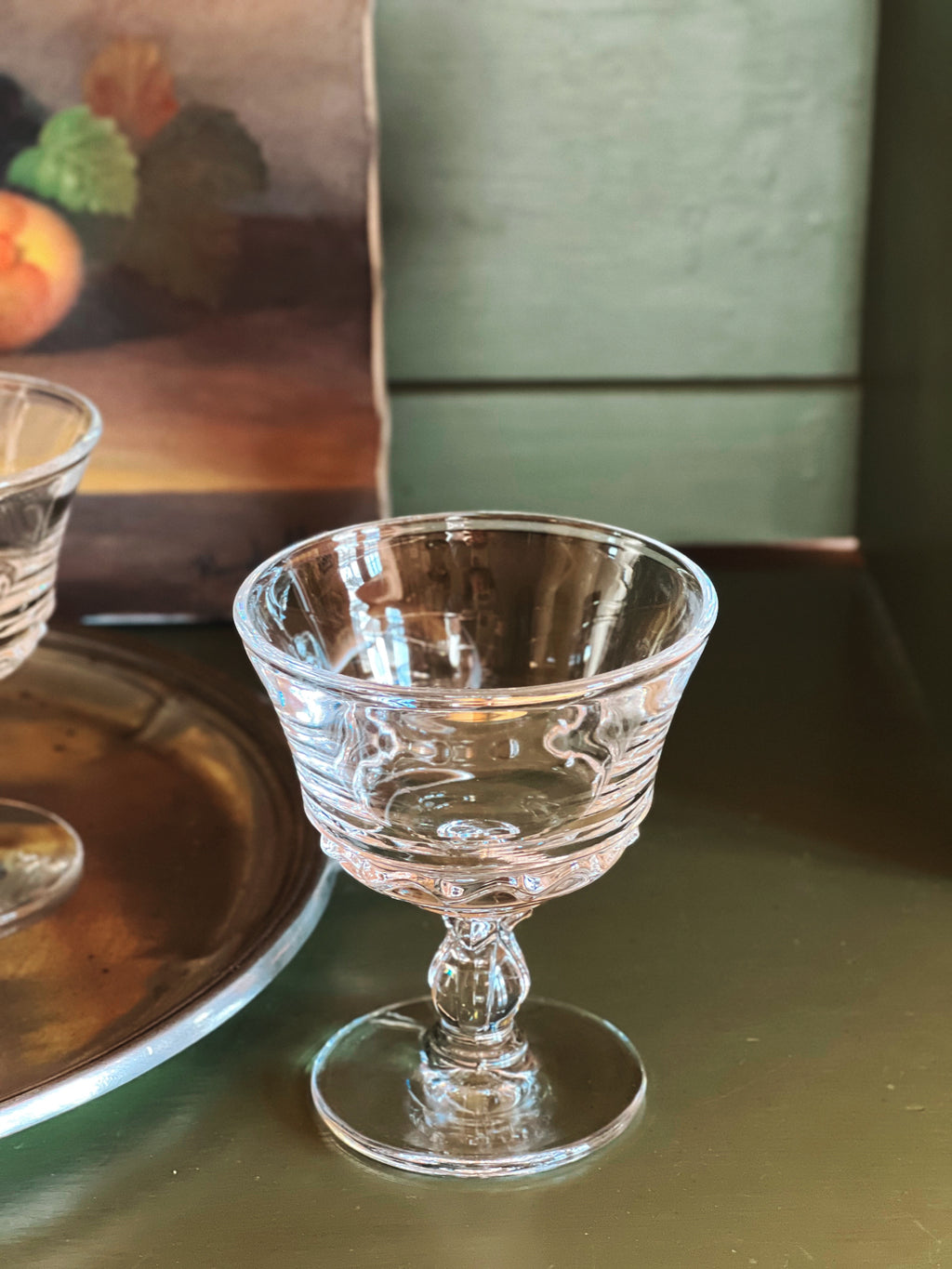 Vintage clear champagne coupe glass with subtle wave pattern base