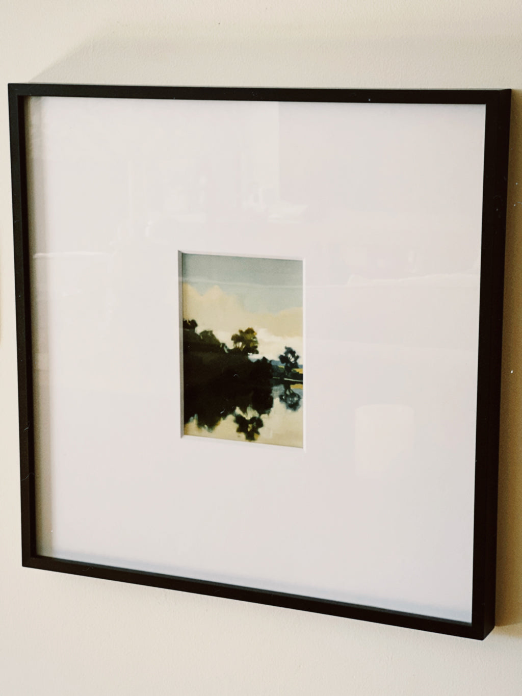 Framed photograph of a landscape with trees against a sky.