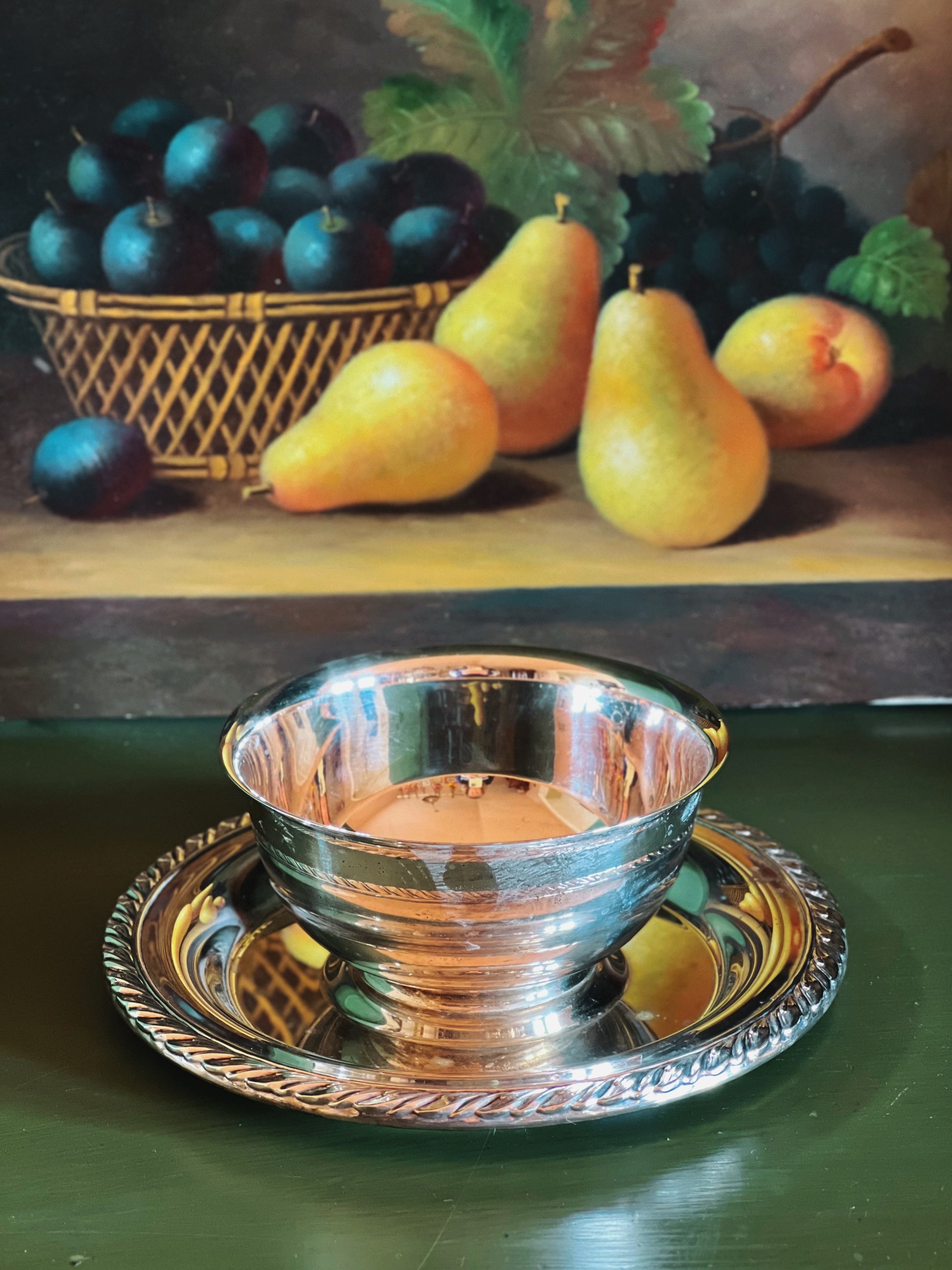 Silver bowl and tray with fruits on a wooden surface