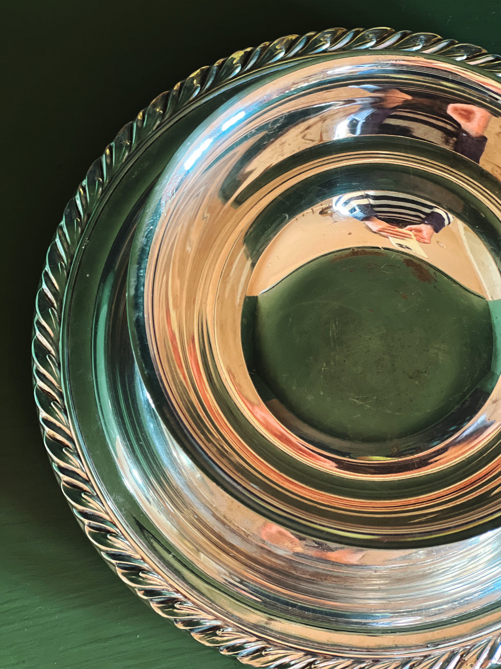 Top and edge view of silver serving bowl showing interior and decorative rim on attached base