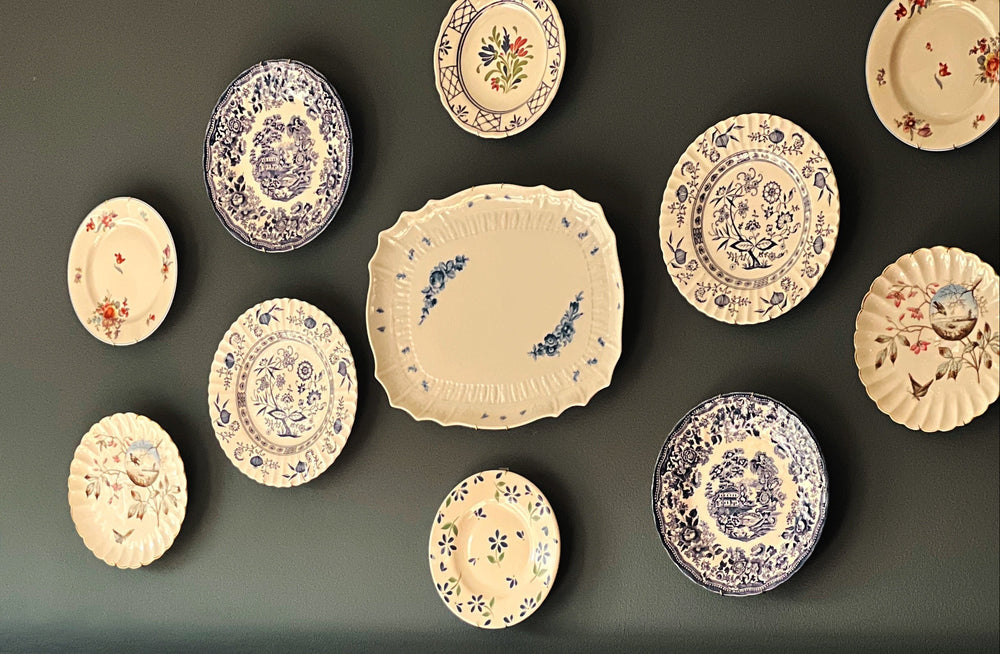 Dining room with decorative plates on the wall above a table.