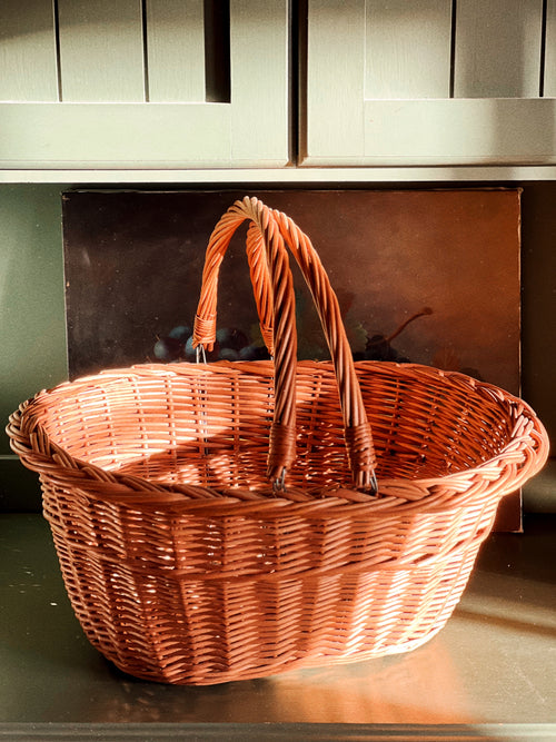 Wicker basket with a handle on a wooden surface