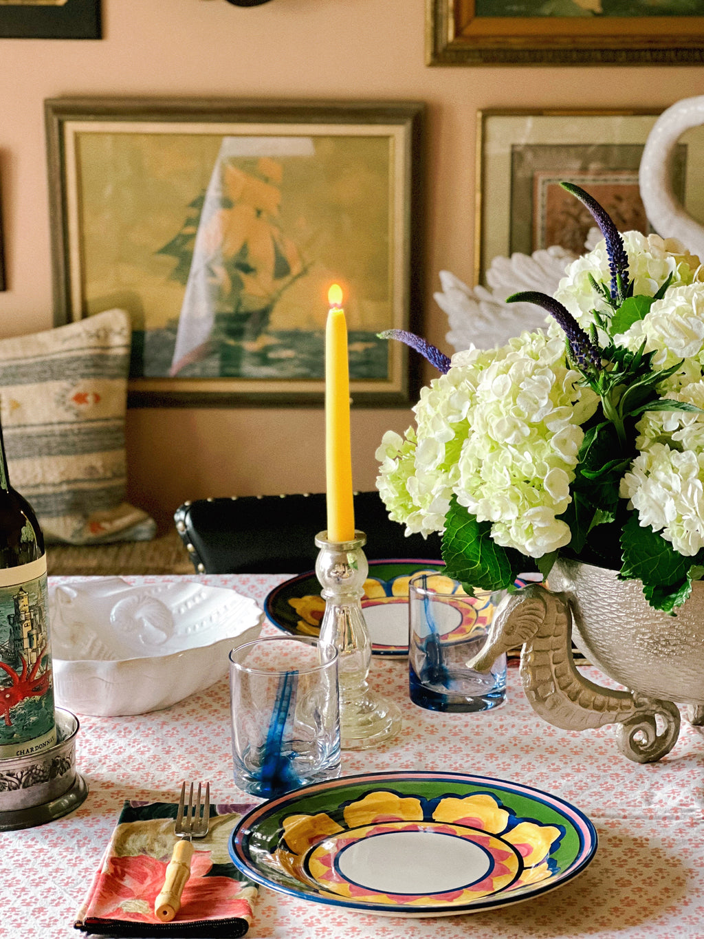Vintage candle holders layered into a coastal-inspired table setting with plates, glassware, and florals