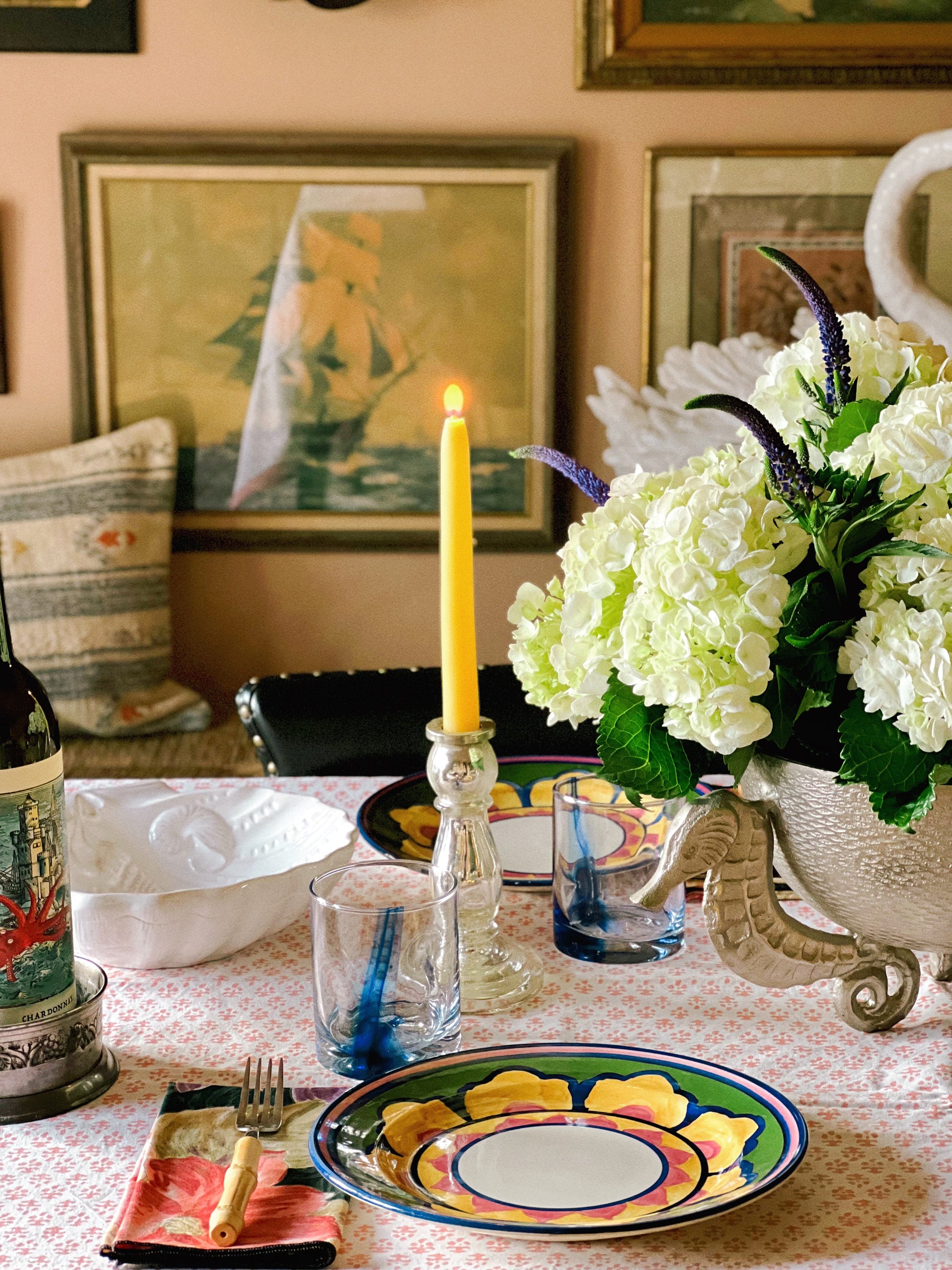 Vintage candle holders layered into a coastal-inspired table setting with plates, glassware, and florals