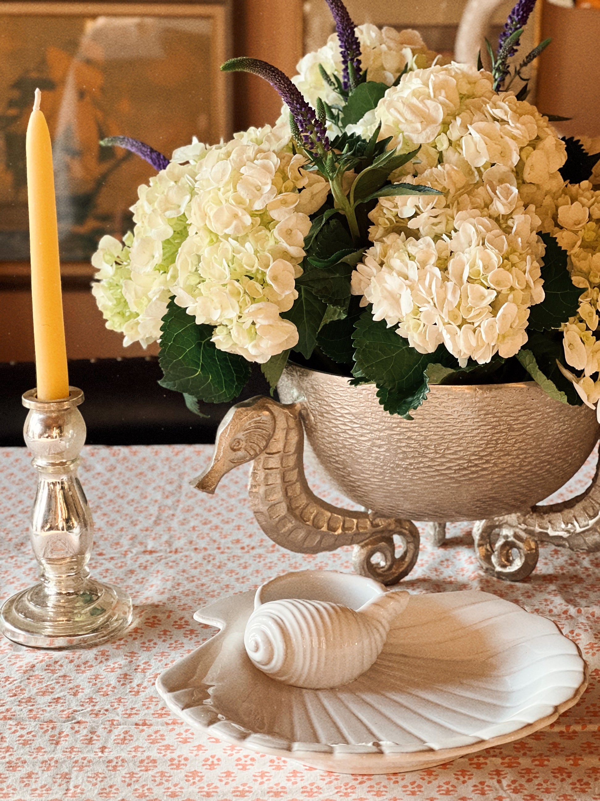 Coastal table setting with scallop shell chip and dip dish and layered serveware