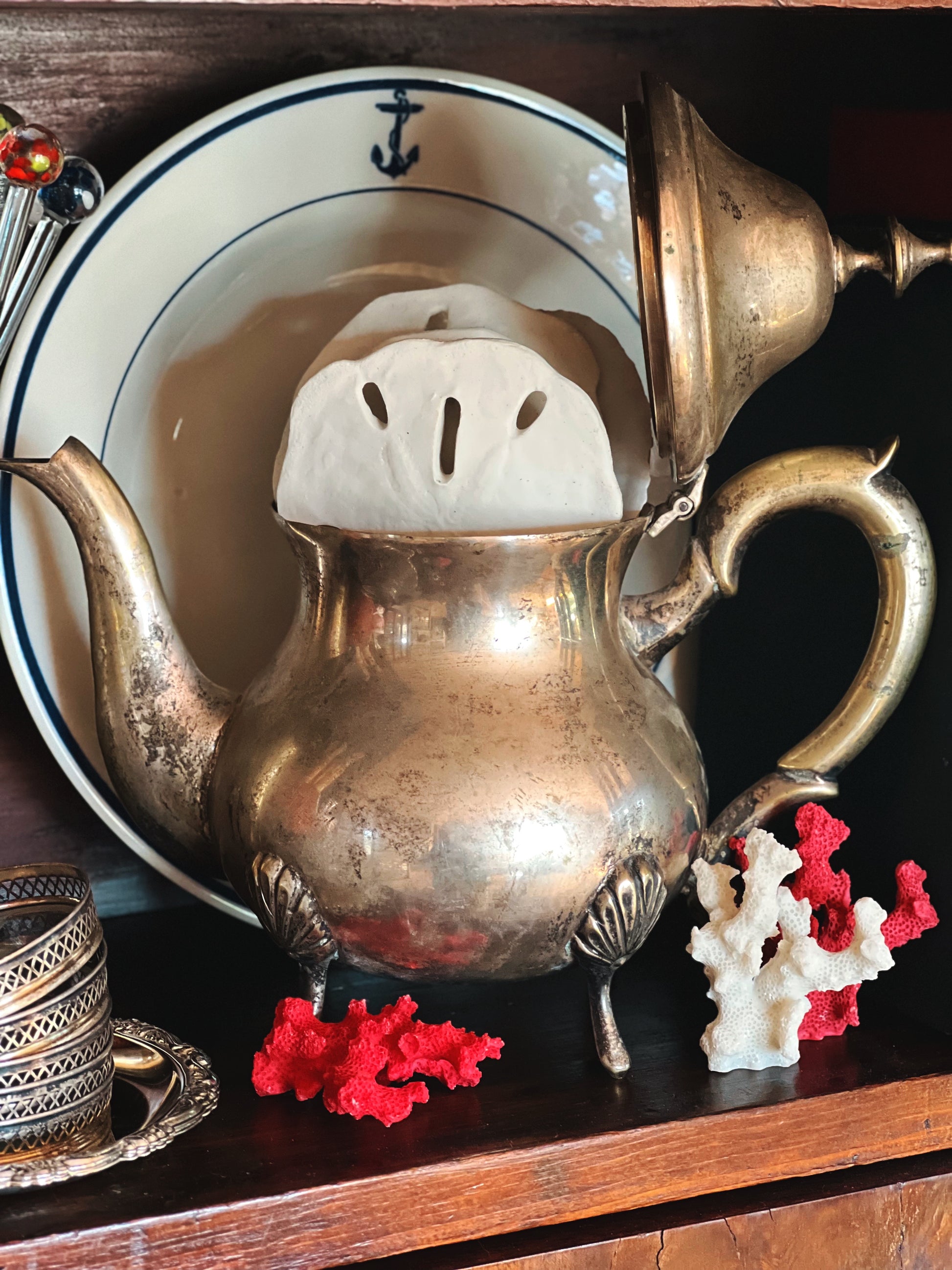 Vintage silver coffee pot with aged patina styled on shelf