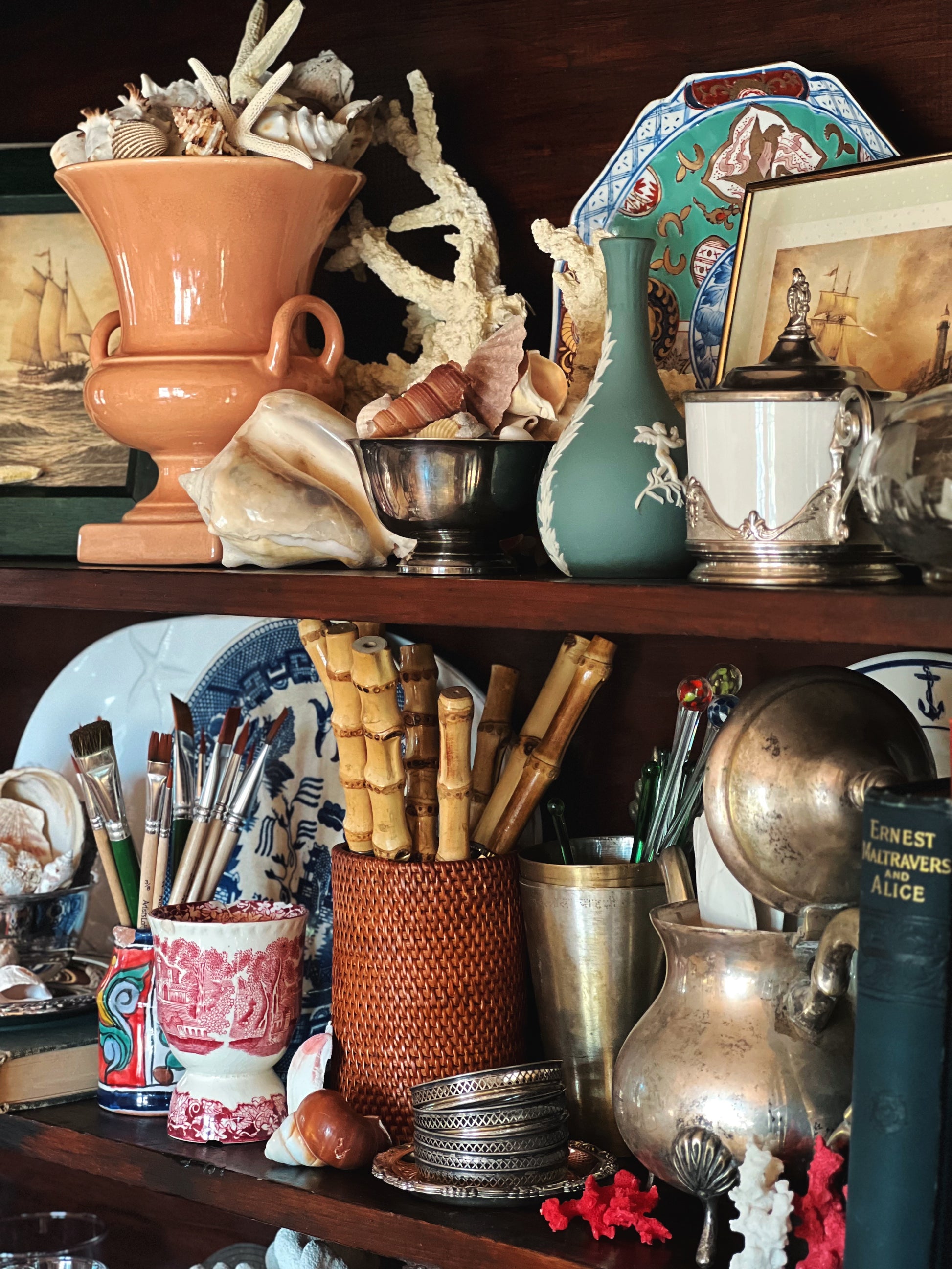 Vintage rattan container used as a utensil holder styled on a shelf with collected decor