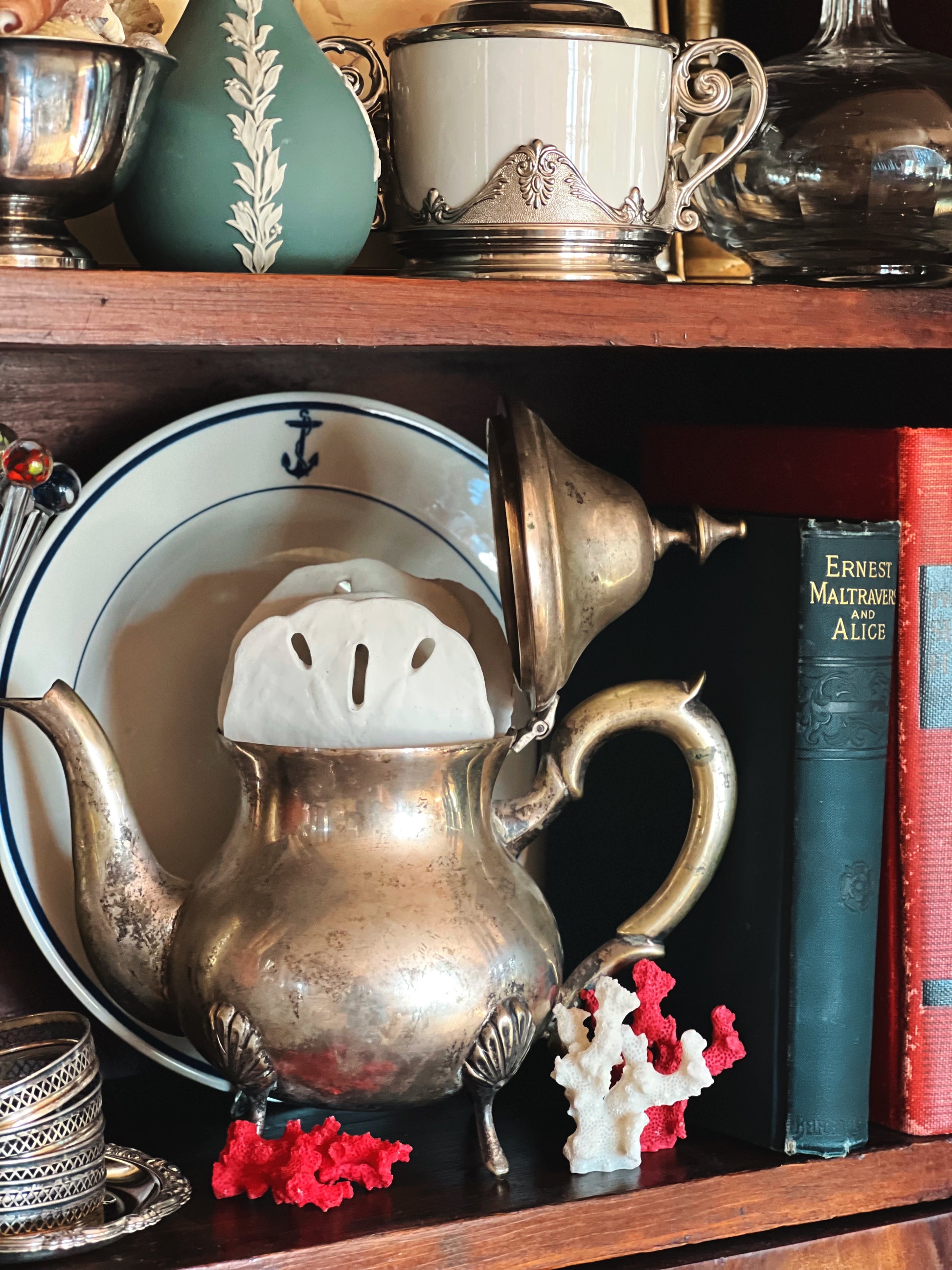 Vintage silver teapot styled with plates and decor vignette