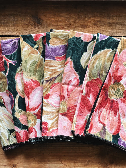 Set of vintage floral cloth napkins folded to show bold multicolor pattern