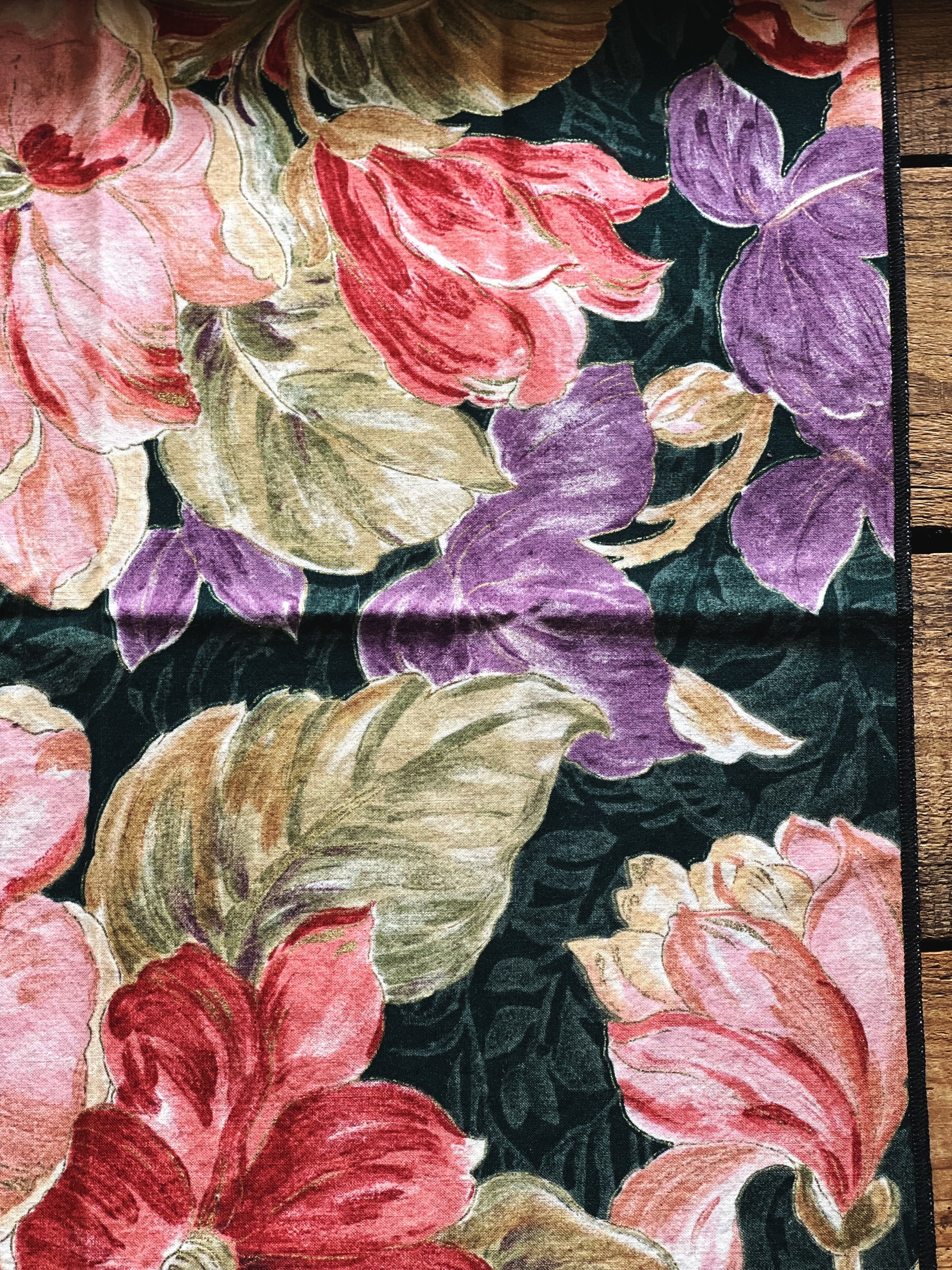 Close-up of vintage floral fabric showing pink, purple, and green tones