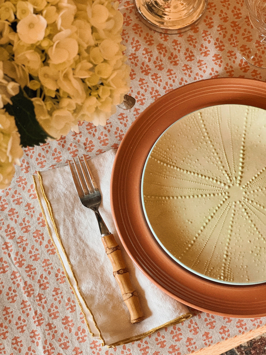 Set of vintage apricot stoneware dinner plates layered with coastal table setting, linen napkin and mixed textures