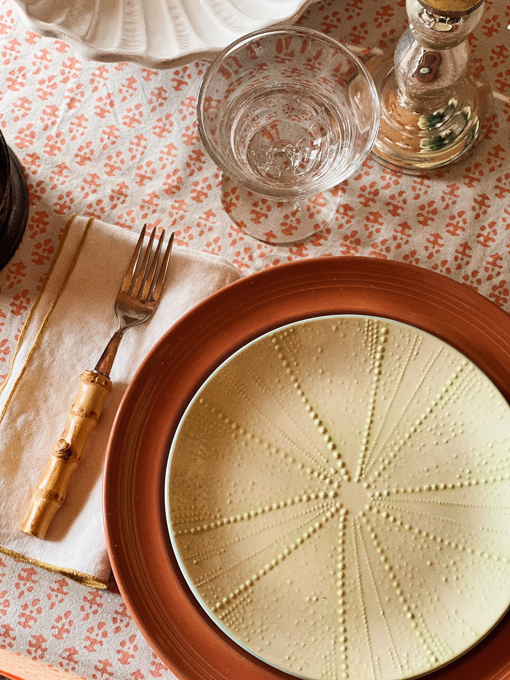 Set of four sea urchin embossed salad plates styled in a layered summer table setting