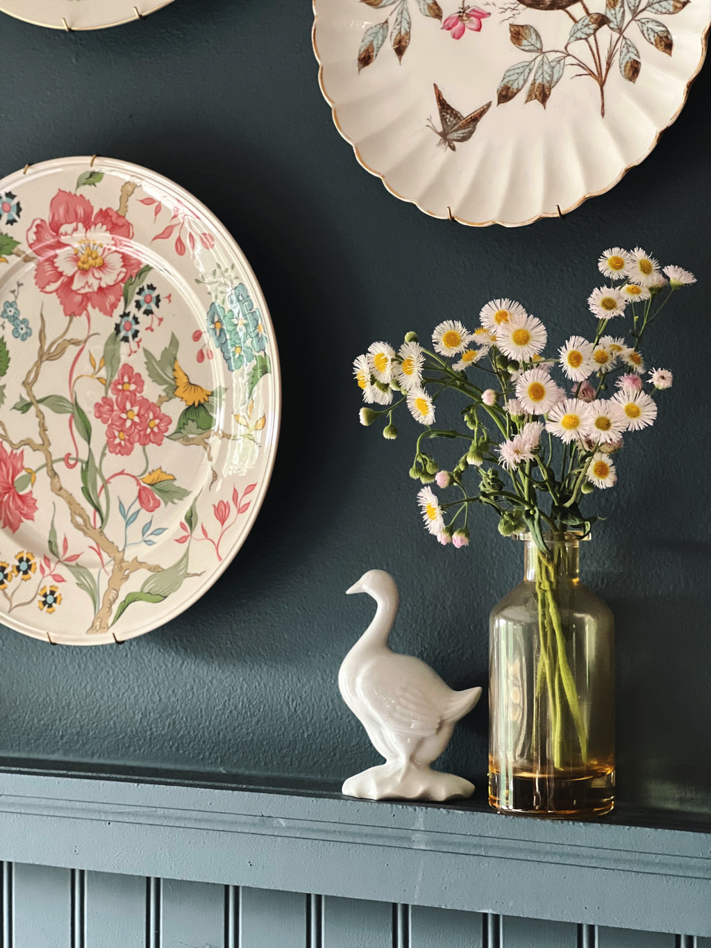 Haviland Limoges goose figurine styled next to flowers on tabletop