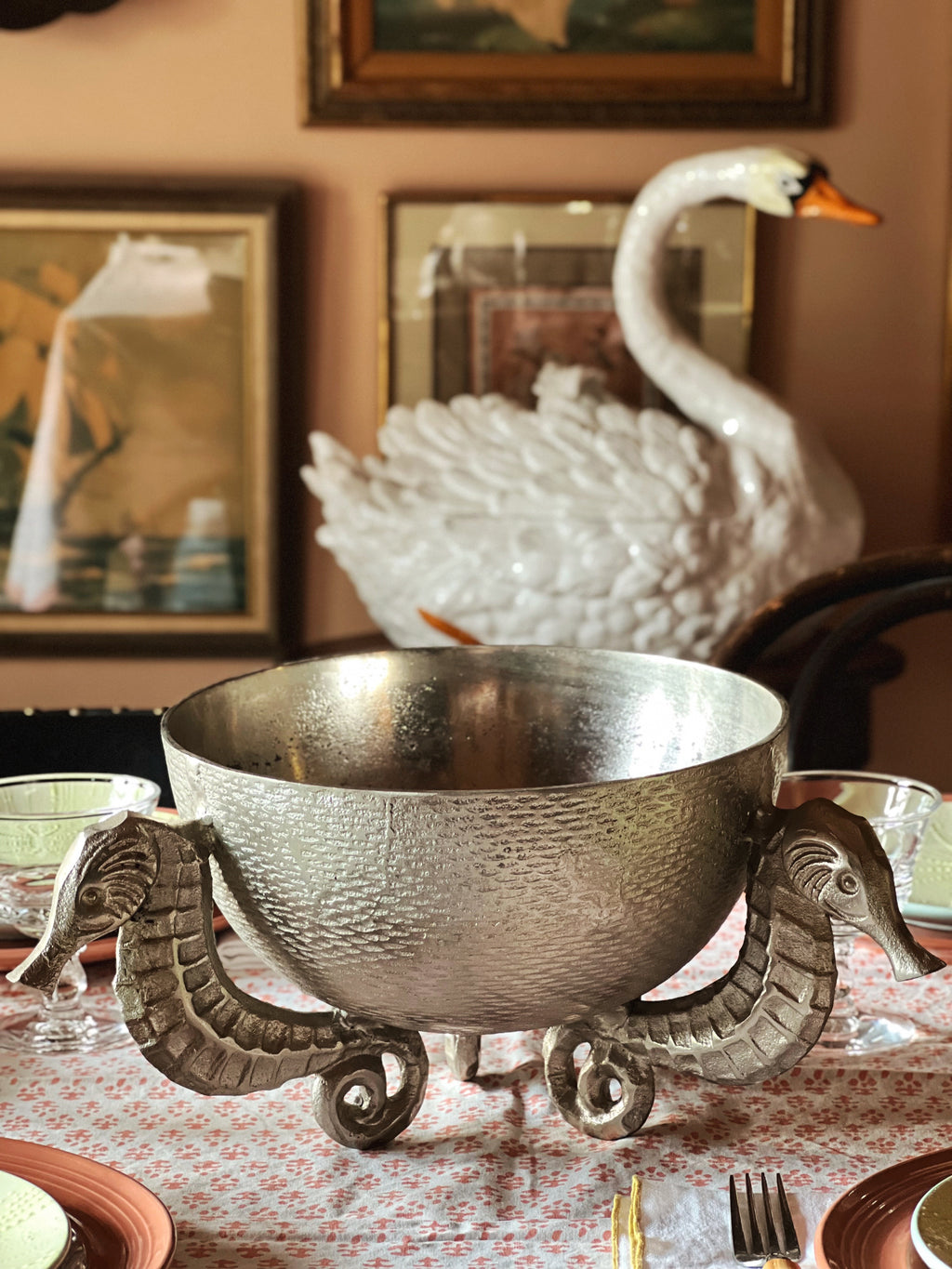 Sculptural vintage silver bowl with seahorse feet used as a coastal centerpiece