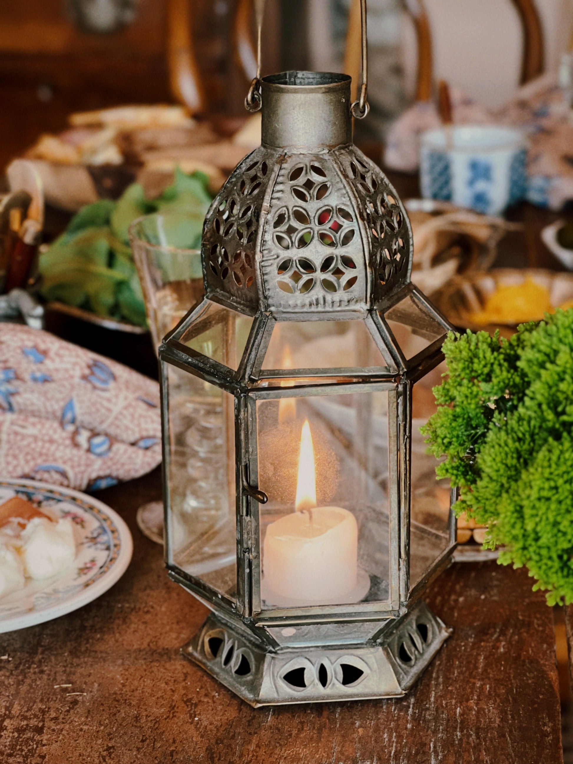 full shot of a moroccan style lantern with a votive candle burning inside