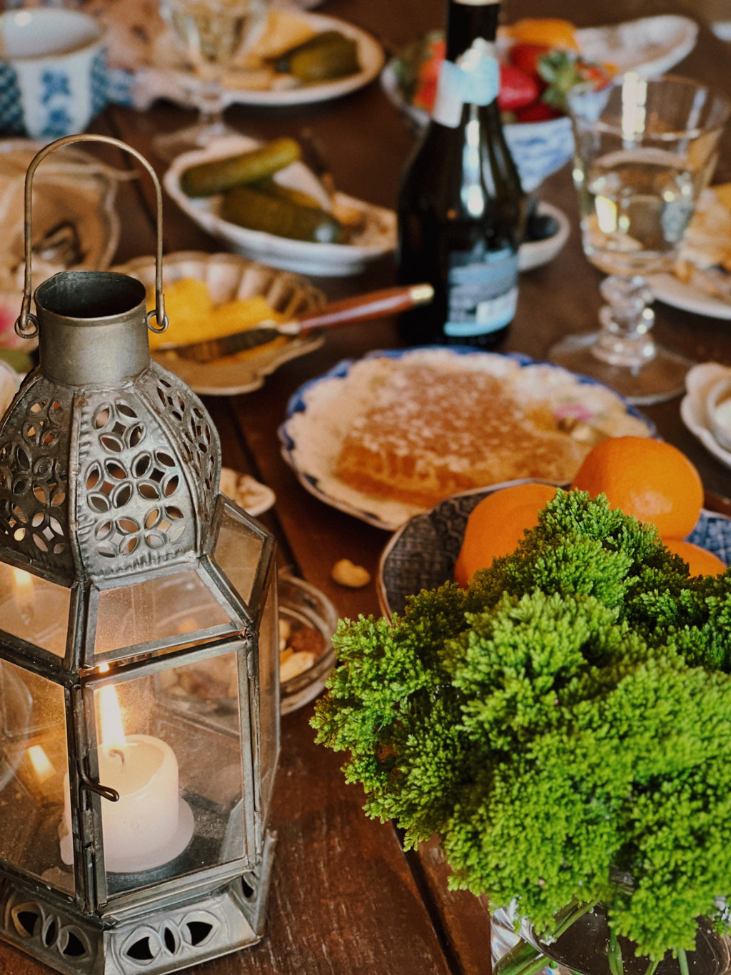 angled view of a tabletop set with charcuterie and a moroccan style candle lantern as table decor