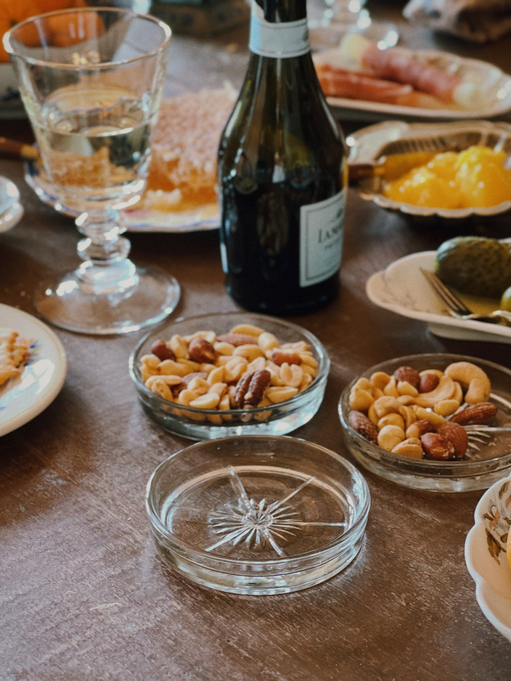 vintage glass coasters holding nuts and small bites on rustic table setting