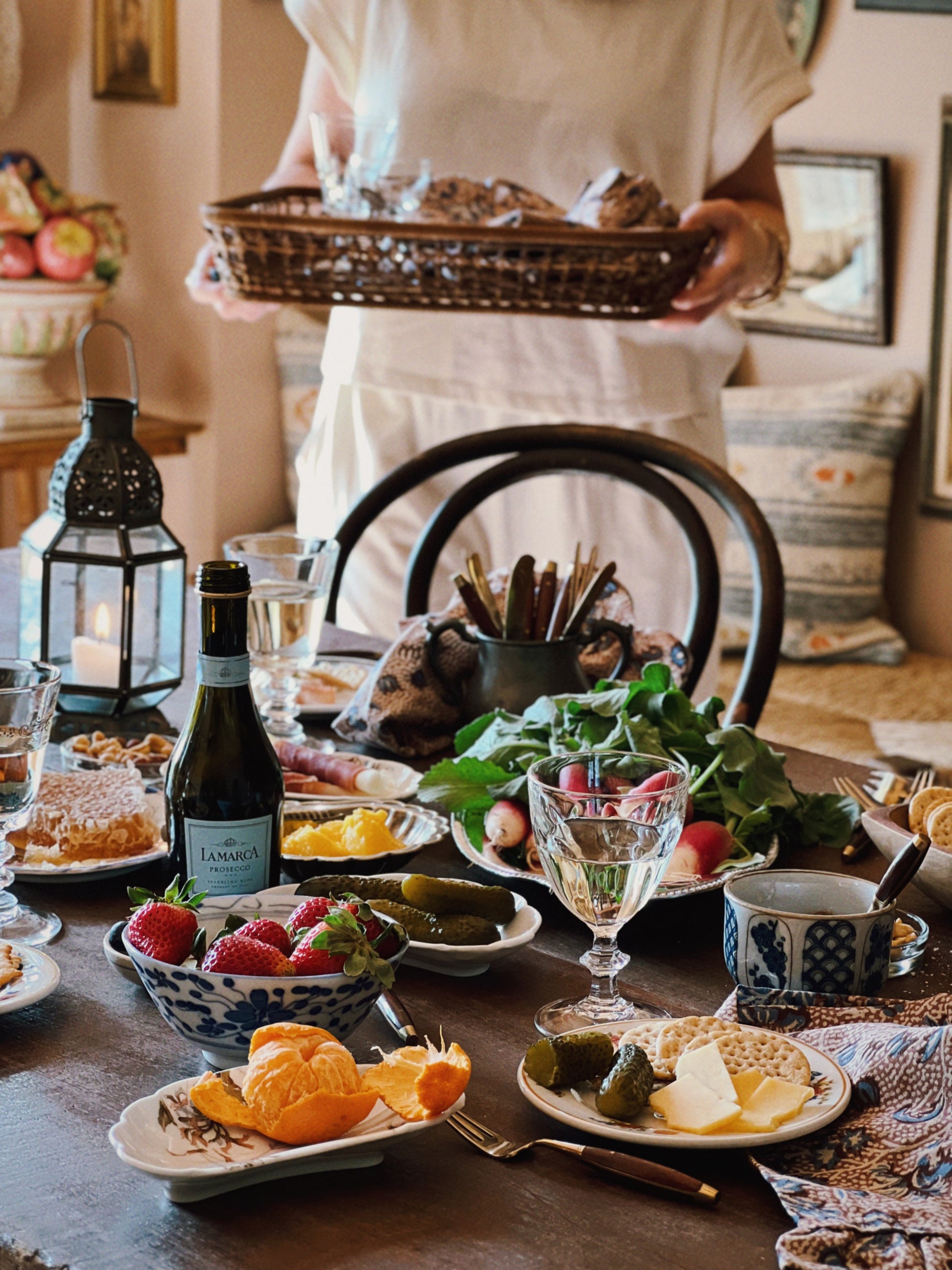 A table filled with charcuterie in vintage serving pieces and mismatched vintage glassware