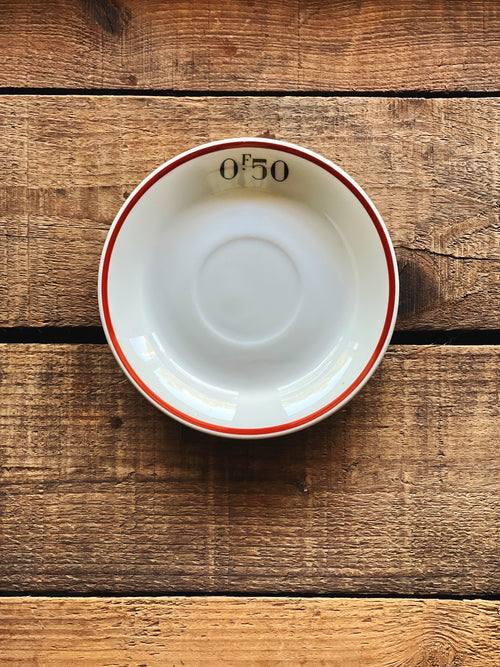 Pillivuyt France white porcelain saucer with red rim detail on rustic wood surface