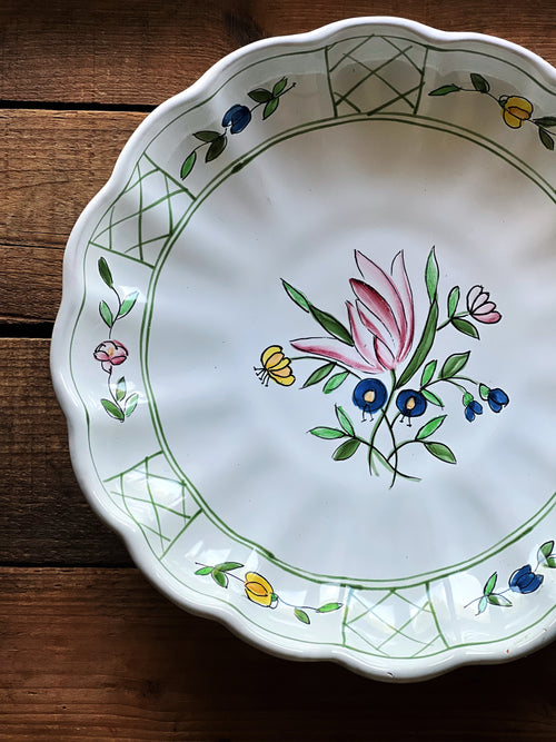 Overhead view of vintage Italian serving bowl showing floral detail and detail of repaired edge on vintage serving bowl