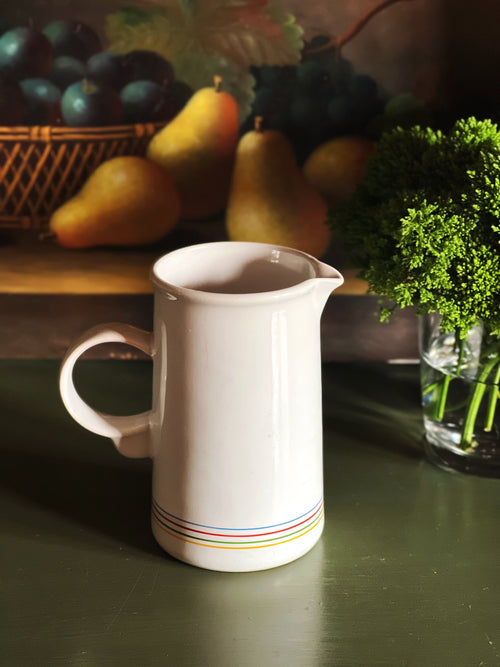 Side view of vintage striped ceramic creamer showing handle and shape