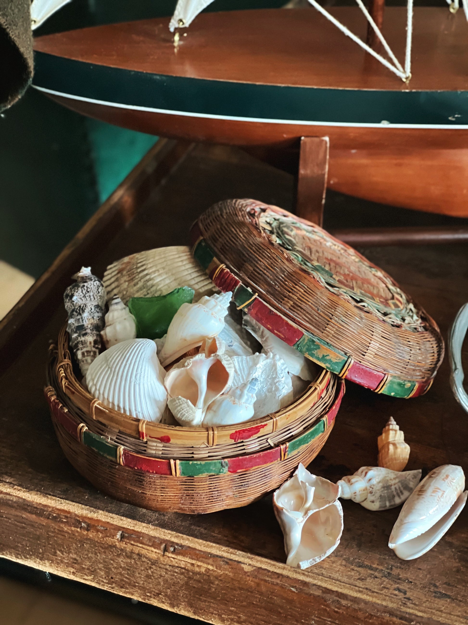 vintage bamboo basket with lid styled with seashells on wooden tray