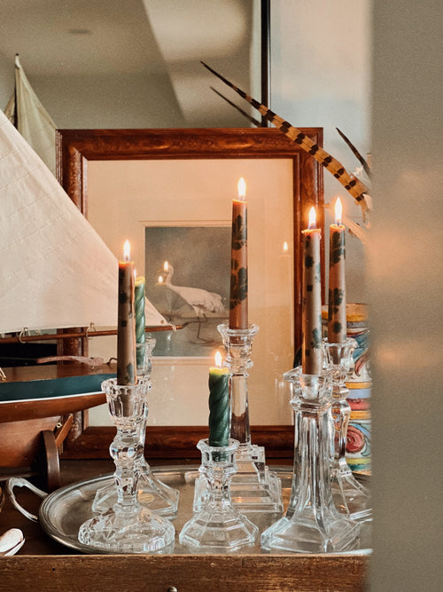 framed coastal bird artwork styled behind crystal candlesticks