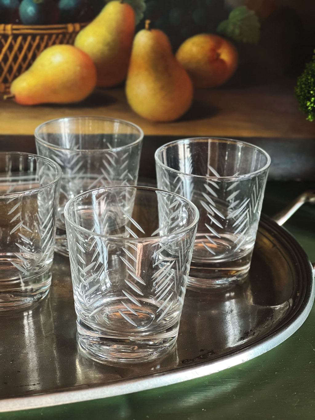 Vintage etched cocktail glasses arranged on a silver tray 