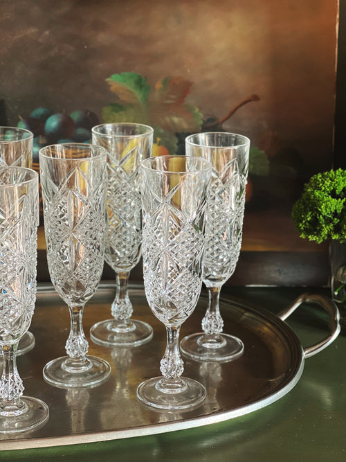 Set of elegant crystal glasses on a reflective surface with a blurred background