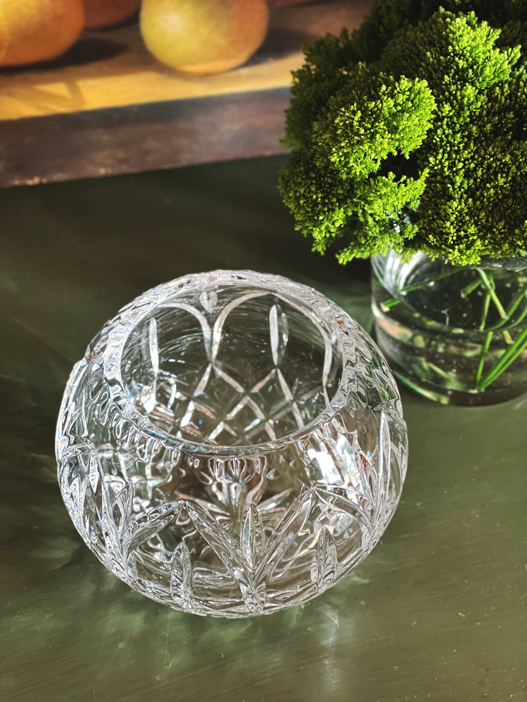 Overhead angle of a decorative crystal vase on a reflective surface with blurred background