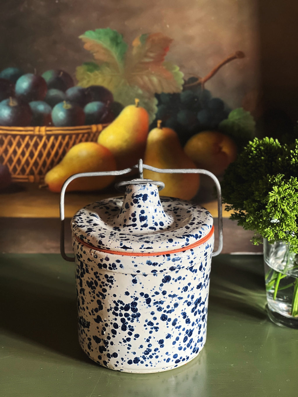 Side view of vintage spongeware crock with metal bail handle and lid attached