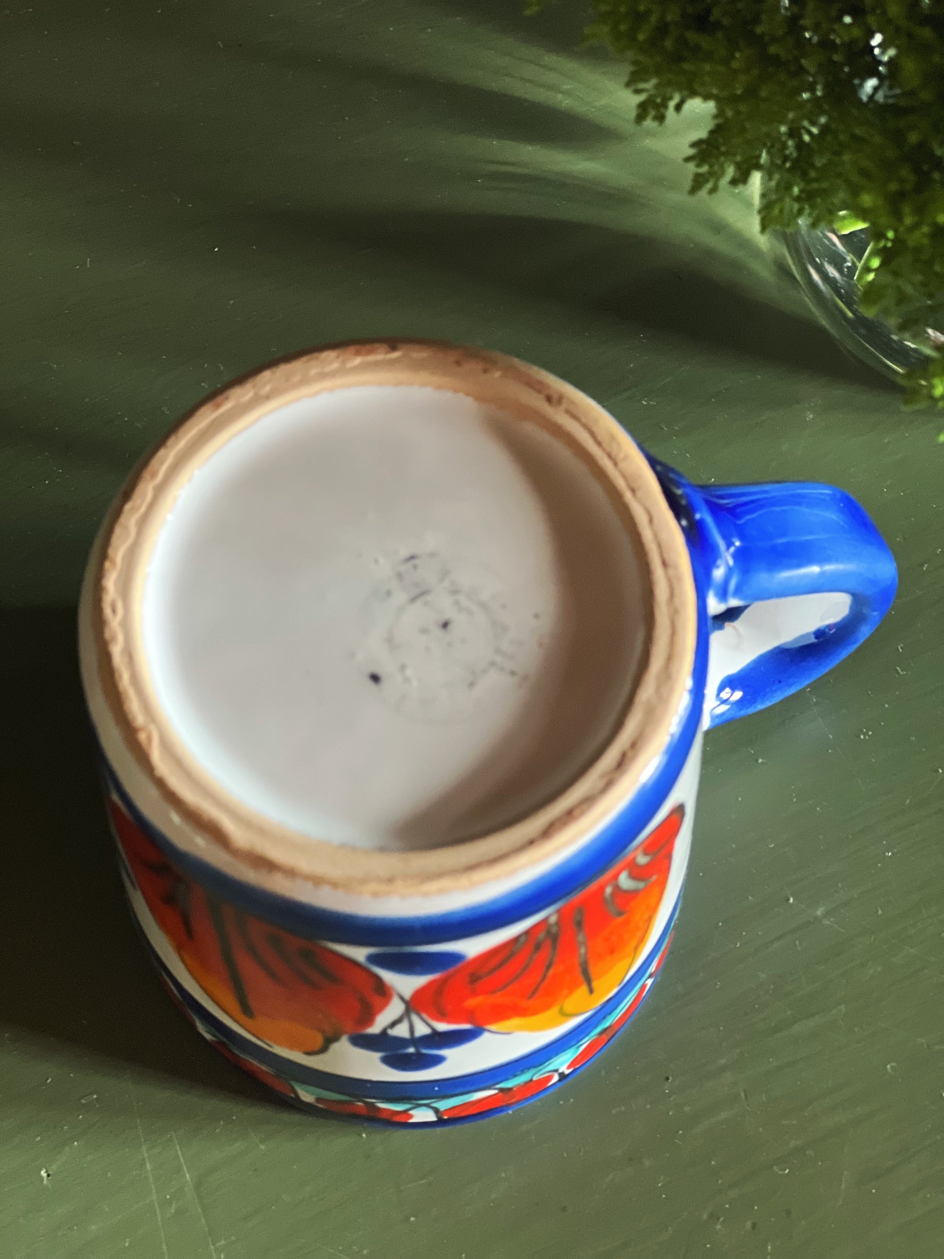 Overhead view of hand painted mug with curved handle and decorative pattern