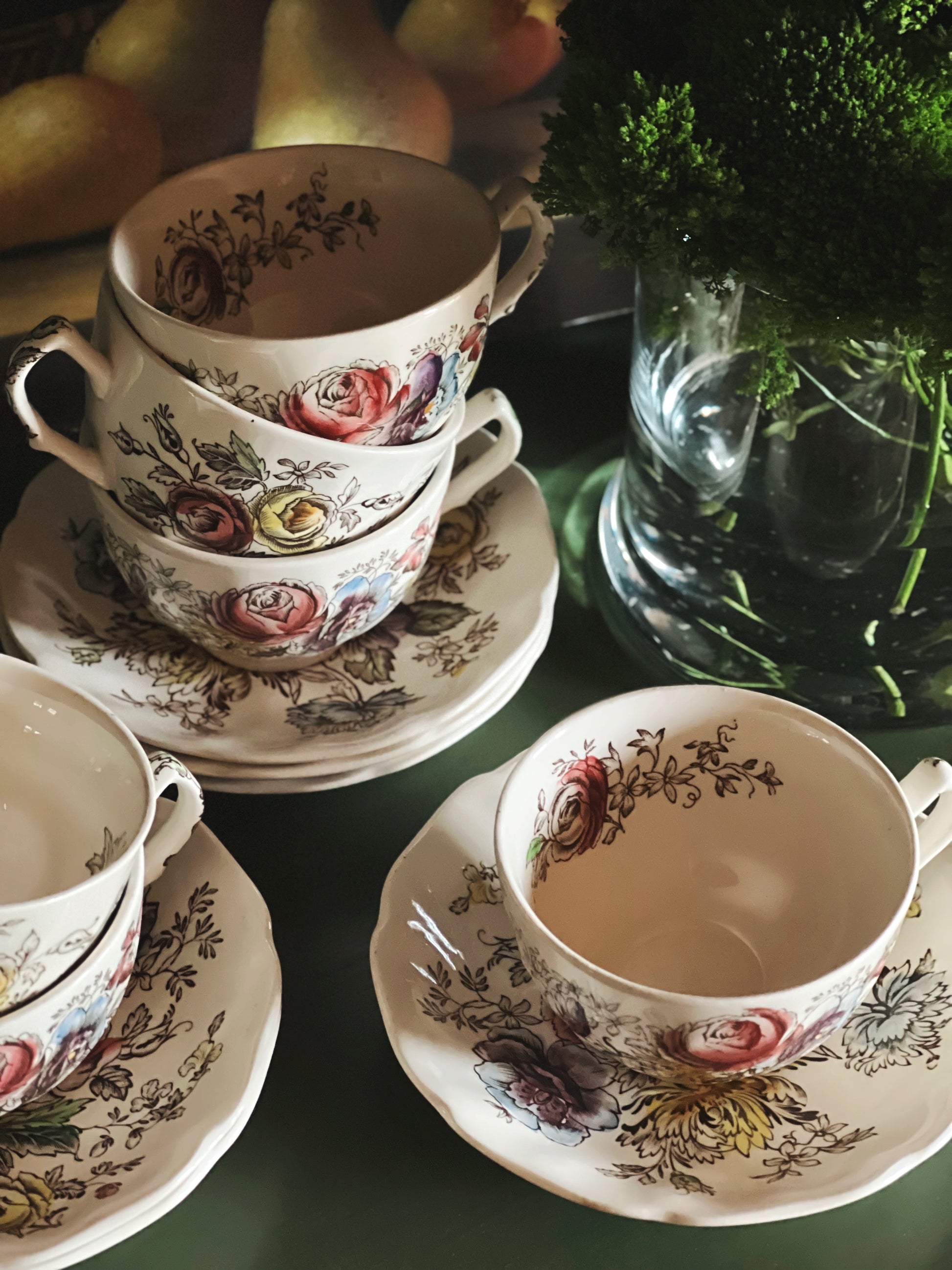 Vintage floral teacup and saucer set styled against a moody still life backdrop