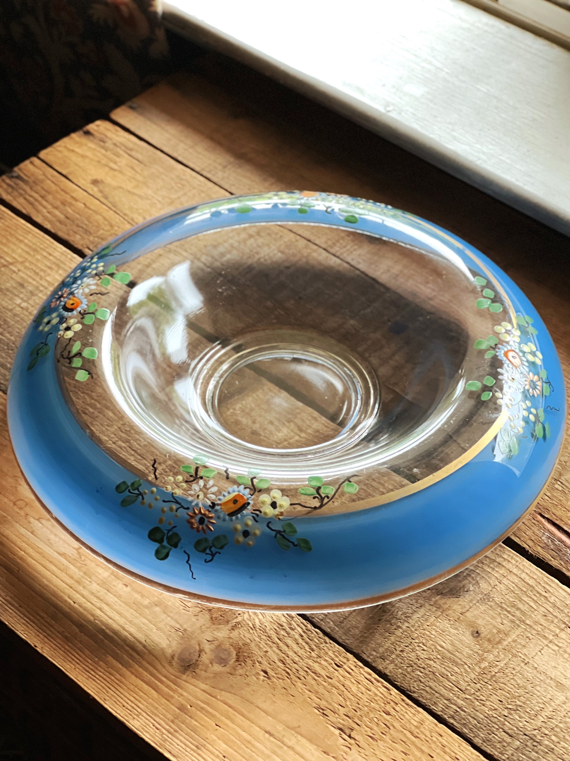Clear glass dish with floral designs on a rustic wooden surface