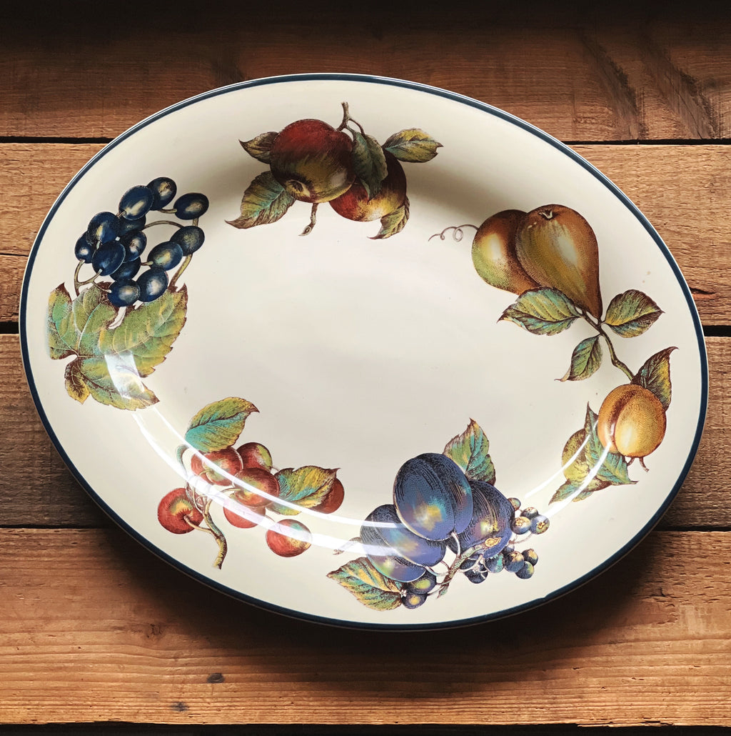 full overhead view of a Pier 1 Macintosh oval serving platter on a rustic wood surface