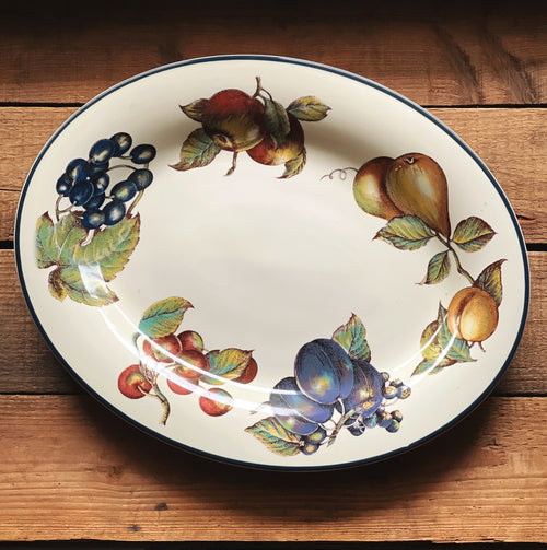 full overhead view of a Pier 1 Macintosh oval serving platter on a rustic wood surface
