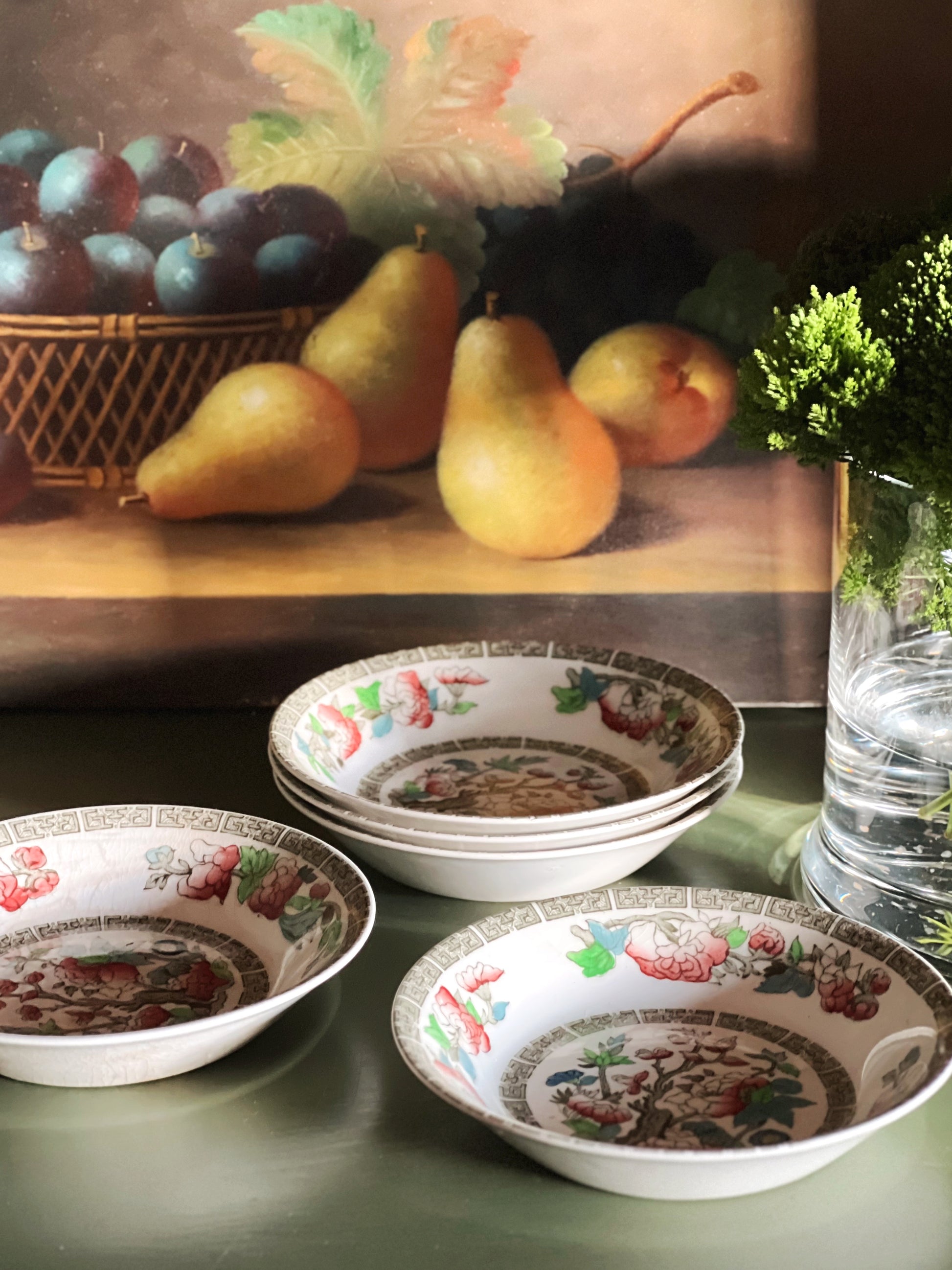 Vintage floral berry bowls beside pears and layered cottage decor