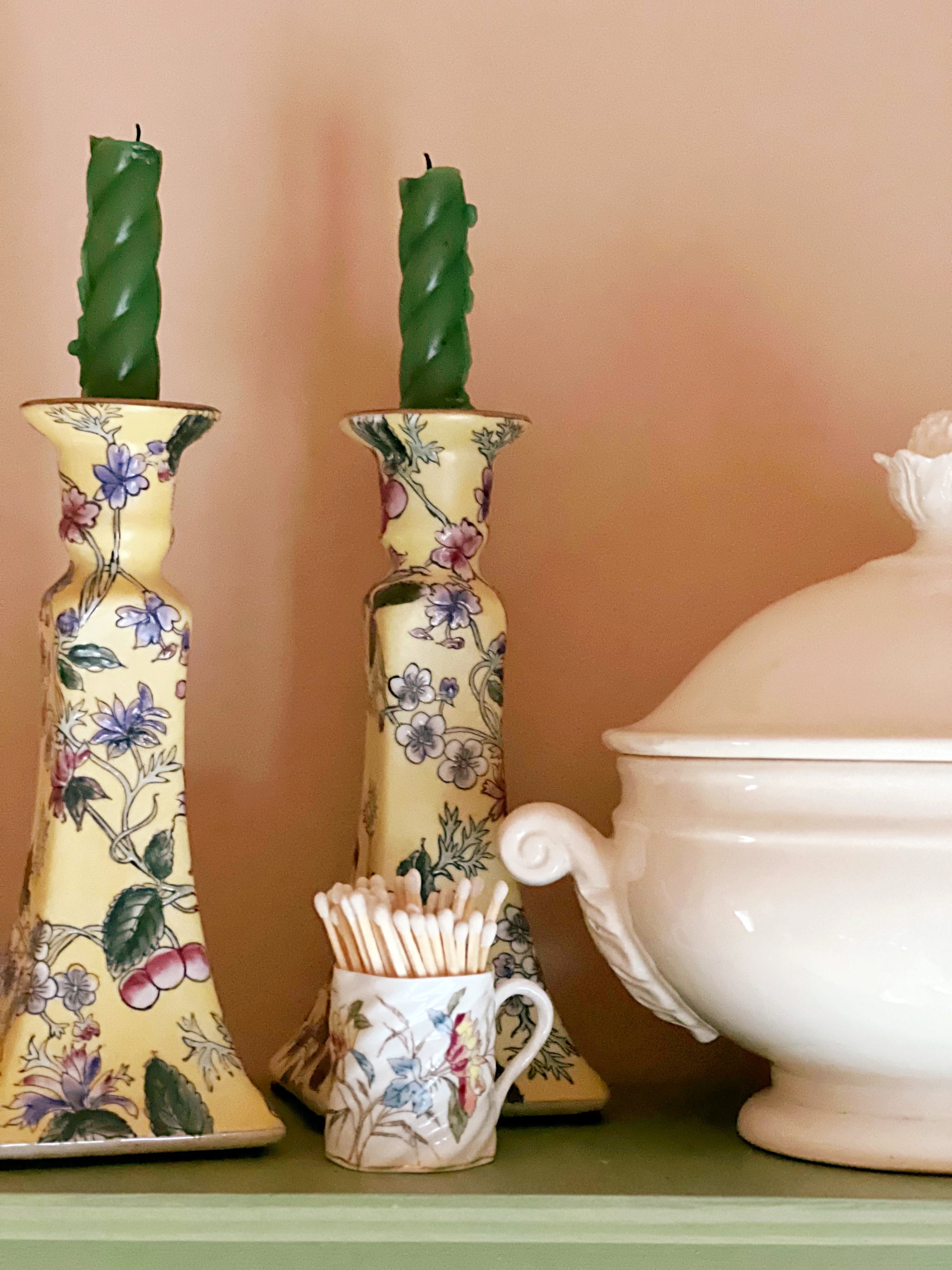 Vintage floral candlesticks styled on cottage kitchen shelves beside collected ceramics