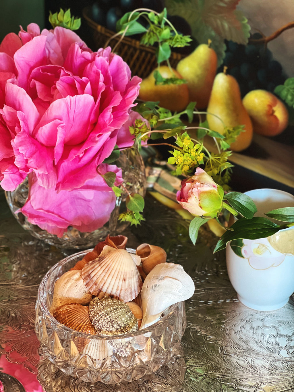 Small crystal bowl filled with shells on a silver tray with flowers