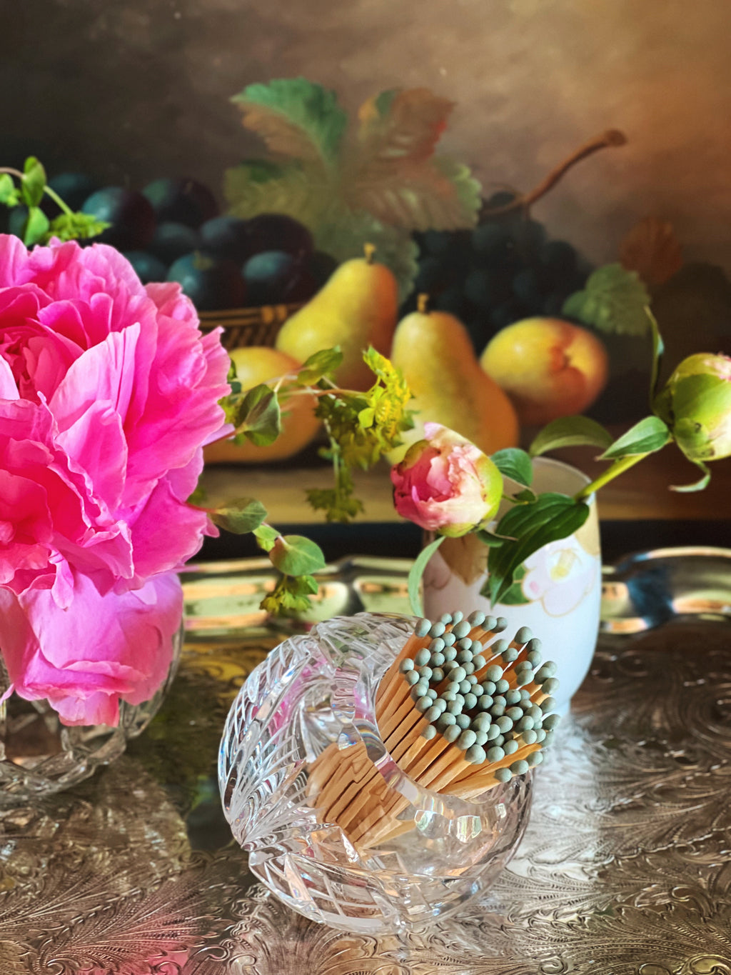 Matched stored in a cut crystal angled bowl next to floral arrangements