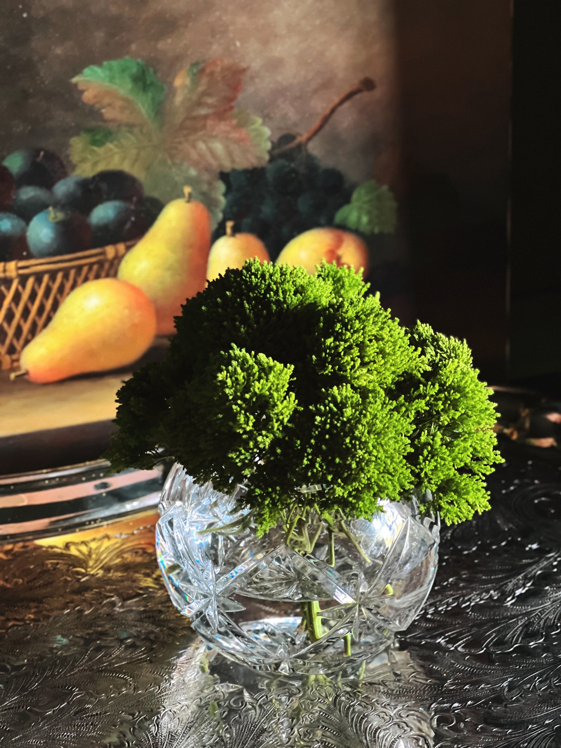 Small vintage cut crystal vase with faceted detail styled beside fruit and greenery