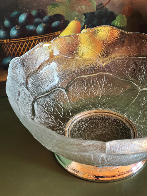 Large vintage glass serving bowl with pressed leaf pattern and silver footed base styled with pears in moody natural light