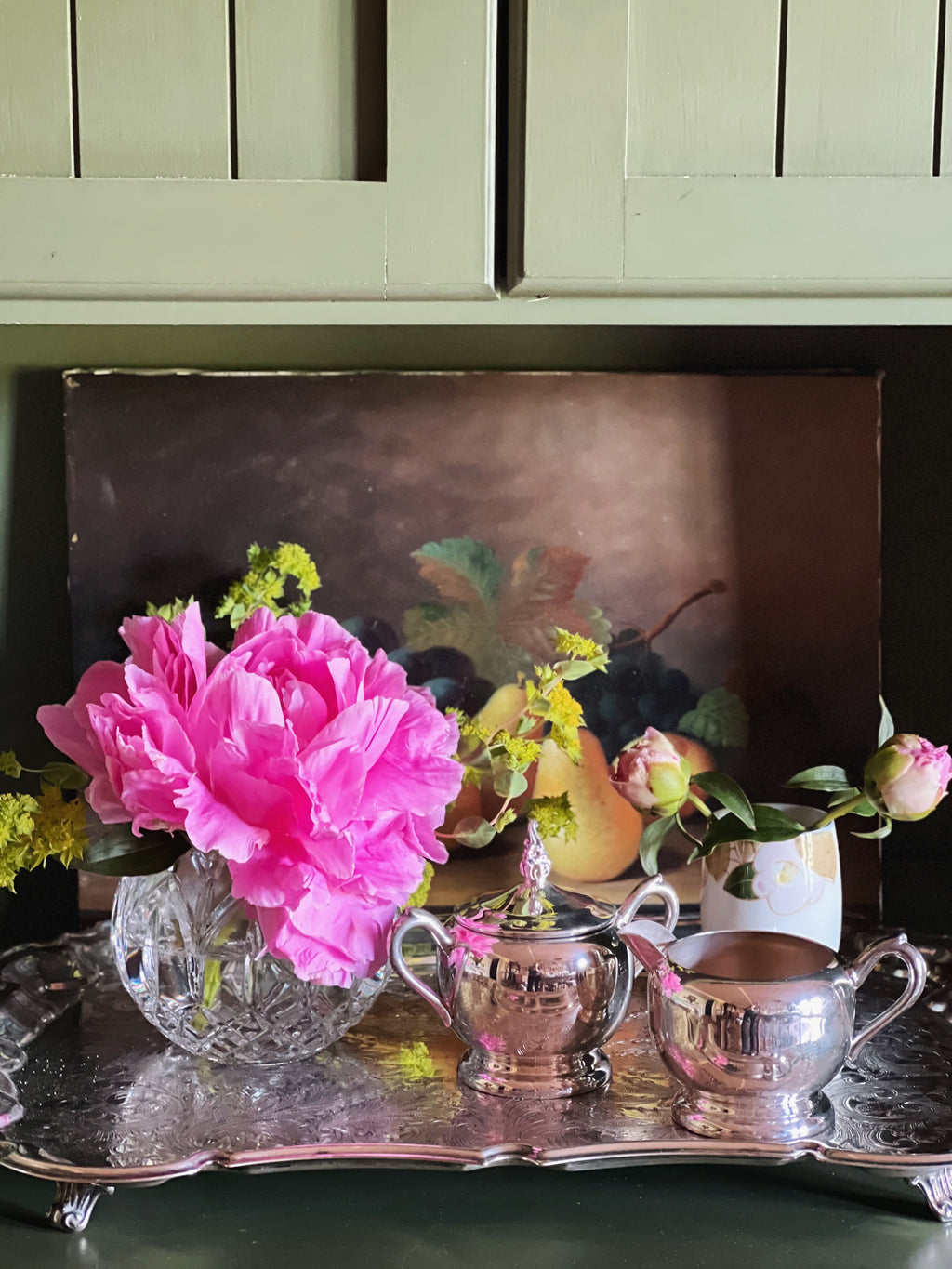 Large vintage Leonard silverplate butler’s tray with pink peonies and silver pieces reflected in the ornate engraved surface